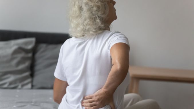 Senior woman massages her back