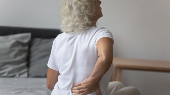 Senior woman massages her back
